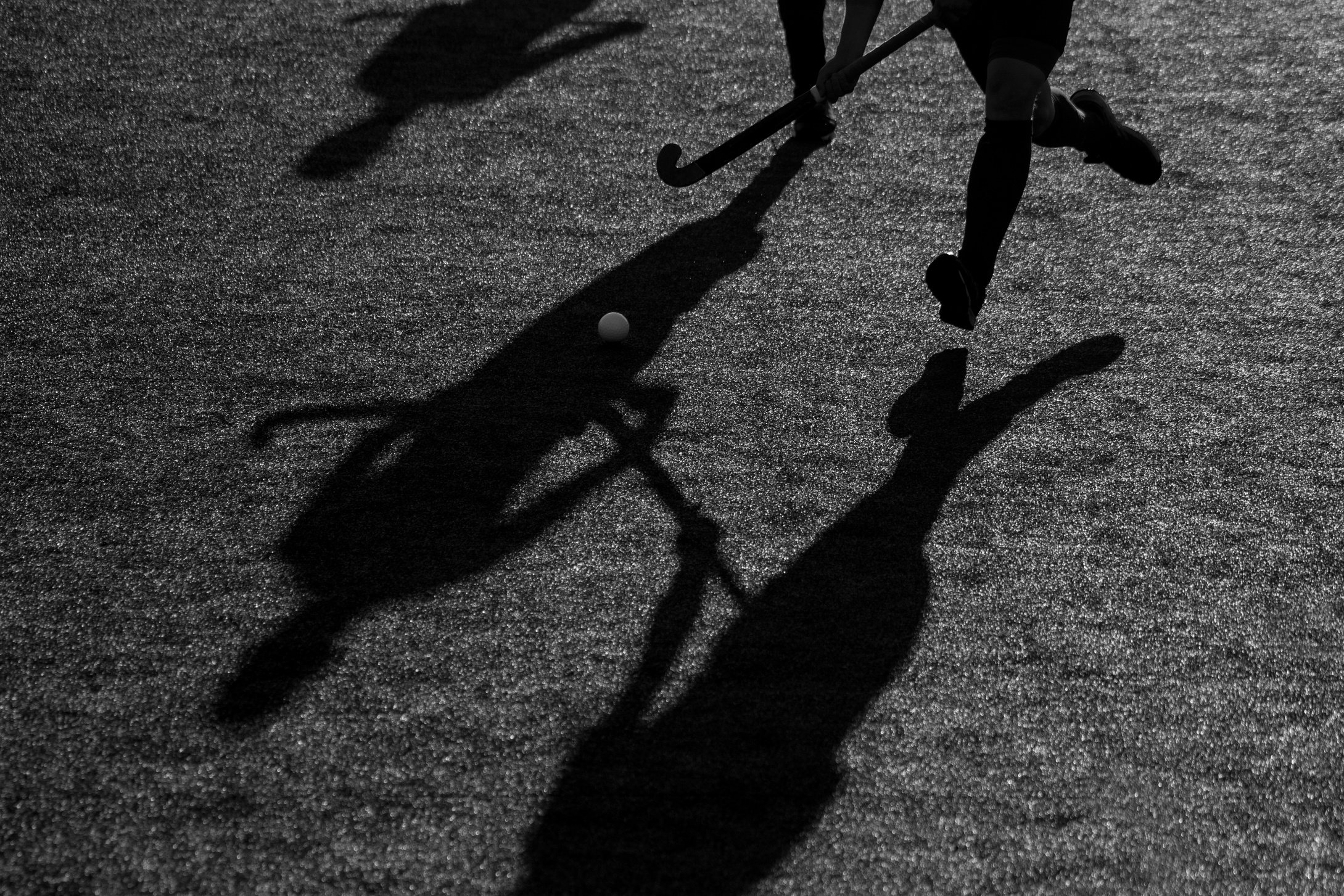 Silhouette. The shadow of a hockey player is running with a hockey stick on a hockey field.